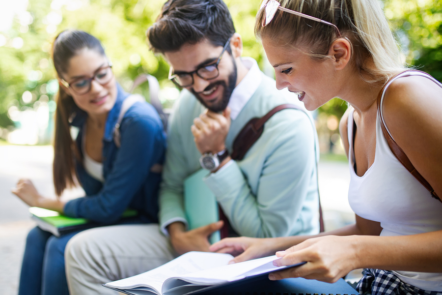 Happy young university students studying together. Group of multiracial friends in college