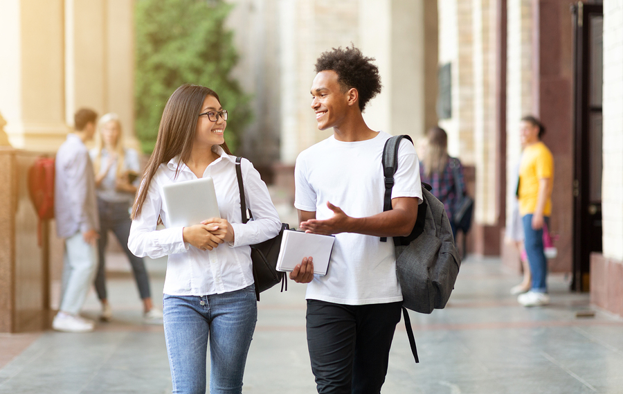 Young student couple going to college class, walking trough university campus