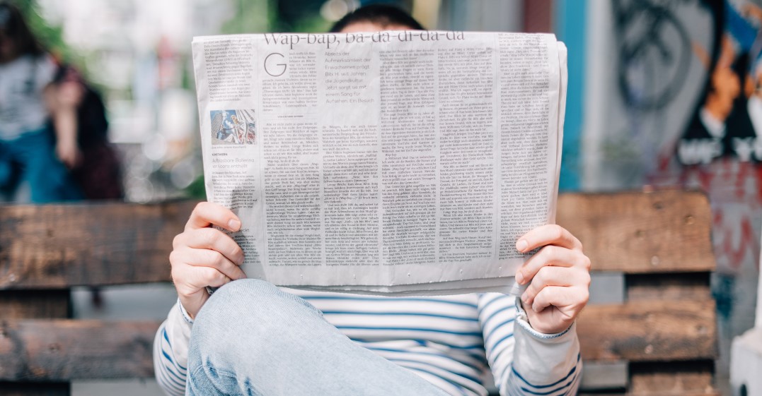 A man holding a newspaper learning English with newspaper articles