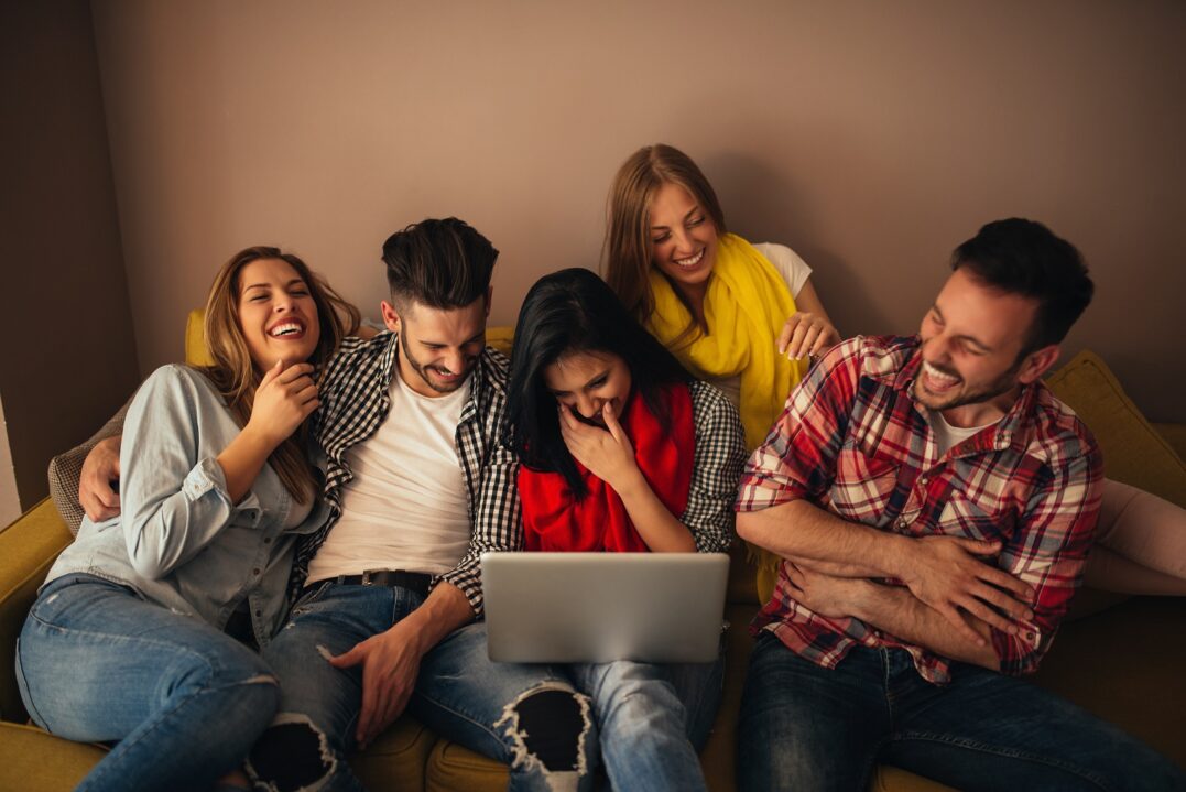 Group of friends looking at German memes and laughing