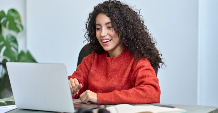 Happy,Young,Latin,Business,Woman,Looking,At,Laptop,Reading,Good