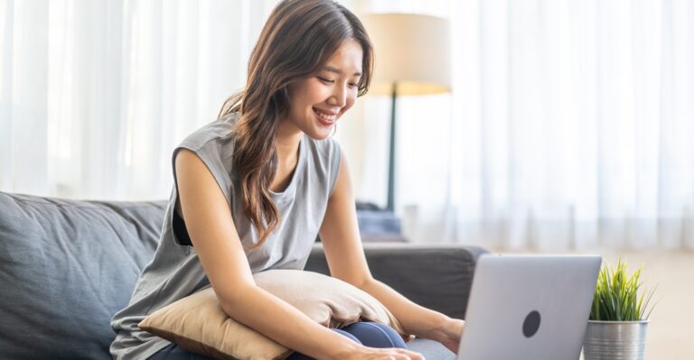 Young Asian woman looking up the best online German classes on her laptop